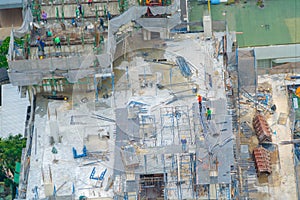 Aerial view of busy industrial under construction site workers working with cranes and excavators. Top view of precast concrete