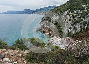 Aerial view of Cala Fuili beach near Cala Gonone, Gulf of Orosei, Sardinia island, Italy. White pebbles beach with