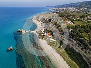 Aerial view of the Calabrian coast, villas and resorts on the cliff. Transparent sea and wild coast