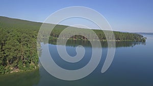 Aerial view on calm forest lake, tree forest backgrounds. Beautiful landscape. Aerial view of trees on the lake shore