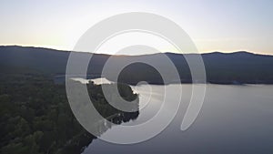 Aerial view on calm forest lake, tree forest backgrounds. Beautiful landscape. Aerial view of trees on the lake shore