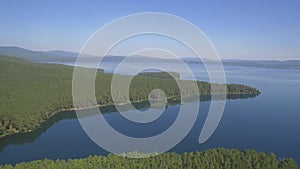 Aerial view on calm forest lake, tree forest backgrounds. Beautiful landscape. Aerial view of trees on the lake shore