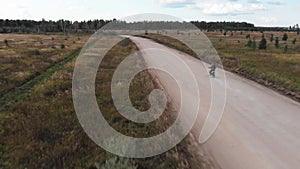 Aerial view, Camera follows of the motocross rider riding on his motorcycle on the off-road track