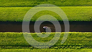 Aerial view of a canal boat in the Netherlands. Canals with water for agriculture. Fields and meadows.