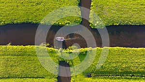 Aerial view of a canal boat in the Netherlands. Canals with water for agriculture. Fields and meadows.