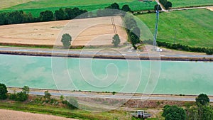 Aerial view of a canal that runs through fields, meadows and arable land in the flat landscape of northern Germany