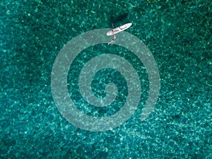 Aerial view of a canoe in the water floating on a transparent sea. Bathers at sea. Zambrone, Calabria, Italy