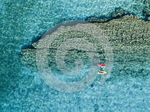 Aerial view of a canoe in the water floating on a transparent sea. Bathers at sea. Zambrone, Calabria, Italy