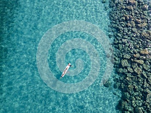 Aerial view of a canoe in the water floating on a transparent sea. Bathers at sea. Zambrone, Calabria, Italy photo