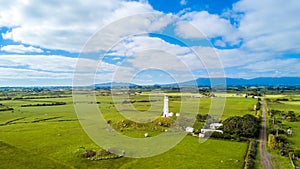 Aerial view on Cape Egmont lighthouse with farmland on the background. Taranaki region, New Zealand