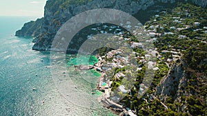 Aerial view of Capri Island with rugged coastline and azure Tyrrhenian Sea in summer Italy. Popular tourist attraction.