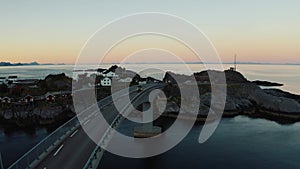 Aerial view of a car crossing a bridge in sunset, Reinefjorden, Lofoten, Norway