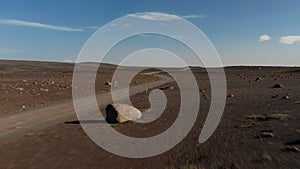 Aerial view car driving in desert stony highlands in Iceland. Drone view vehicle 4x4 speeding off road exploring