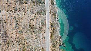 Aerial view of a car riding across the Porto Palermo Fort in Vlora, Albania