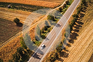 Aerial view of car on the road, driving through beautiful summer countryside landscape