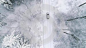 Aerial view of car on road in winter forest/