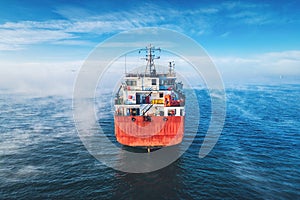 Aerial view of cargo container  ship sails in sea fog, crane vessel working for delivery of delivery containers