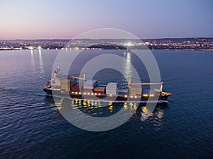 Aerial view of cargo container ship in the sea at night