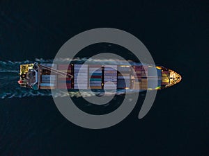 Aerial view of cargo container ship in the sea at night