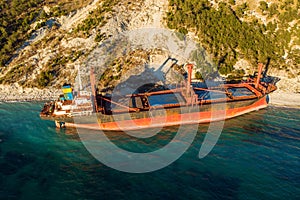 Aerial view of cargo ship run aground on wild coast, shipwreck after storm