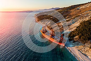 Aerial view of cargo ship run aground on wild coast, shipwreck after storm