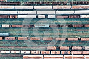 Aerial view of cargo trains. Railway wagons with goods on railroad. Top view of colorful freight train on the railway station.