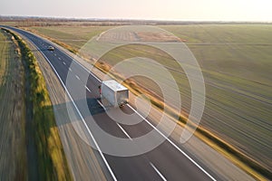 Aerial view of cargo truck driving on highway hauling goods. Delivery transportation and logistics concept