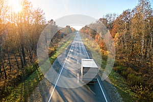 Aerial view of cargo truck driving on highway hauling goods. Delivery transportation and logistics concept