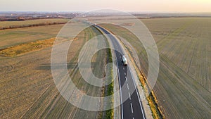 Aerial view of cargo trucks driving on highway hauling goods. Delivery transportation and logistics concept