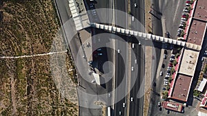 Aerial view of cars driving on an asphalt highway lined with buildings and trees