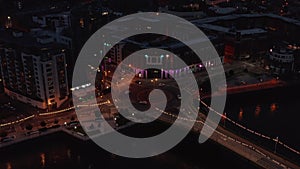 Aerial view of cars driving through roundabout at river waterfront. Low traffic in night city. Limerick, Ireland