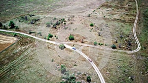 Aerial view of cars go across the field close to Generals' Beaches. Black Sea, Crimea.