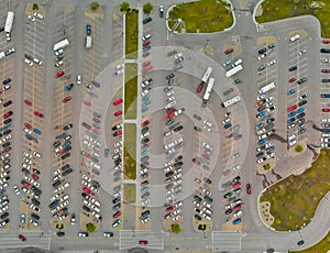 Aerial view of cars at large outdoor parking lots, USA. Outlet mall parking congestion and crowded parking lot, other cars try