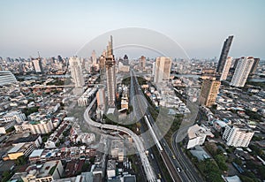 Aerial view of cars and train driving on trident road at Sathorn, Taksin bridge in Bangkok Downtown, Thailand. Financial district