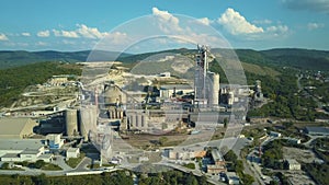 Aerial view of cement factory, large industrial building in the mountains. Concept of cisterns, pipes, metal structures