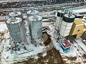 Aerial view of cement factory tower with high concrete plant structure at industrial production area at sunset. Manufacturing and