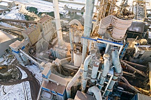 Aerial view of cement plant with high factory structure and tower crane at industrial production area