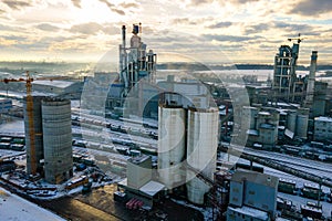 Aerial view of cement plant with high factory structure and tower crane at industrial production area