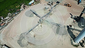 Aerial view of a cement plant at a quarry for the construction industry. Conveyor belt of heavy machinery loads gravel