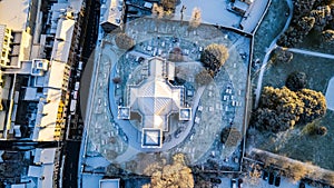 aerial view of a cemetery in a winter day, with trees and graves