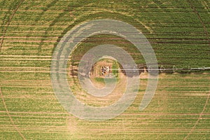 Aerial view of center pivot irrigation equipment watering green soybean seedlings on farm plantation
