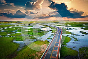 Aerial view of Chalerm Phra Kiat road at sunset in Thale Noi, Phatthalung, Thailand