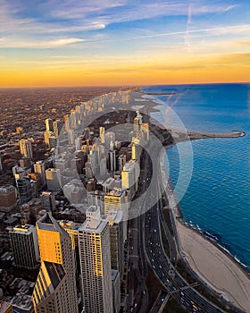 Aerial view of the Chicago skyline featuring numerous high-rise buildings at sunset.