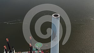 Aerial view of the chimney of Esbjerg Power Station in Denmark. Drone view revealing Liebherr Seafox 5, the biggest
