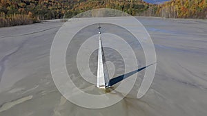 Aerial view of a choked church in a decanting lake, industrial mining landscape