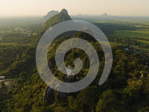 An aerial view of Christ the Redeemer and Buddha on the mountain stands prominently at Hup Pha Sawan in Ratchaburi