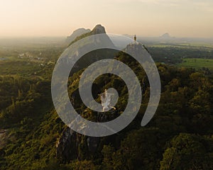 An aerial view of Christ the Redeemer and Buddha on the mountain stands prominently at Hup Pha Sawan in Ratchaburi