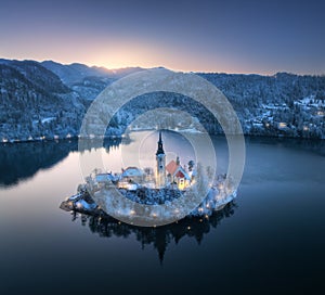 Aerial view of church, snowy island on the Bled Lake at night