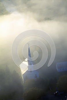 Aerial view of church steeple wreathed in morning fog in autumn, Waitsfield, VT