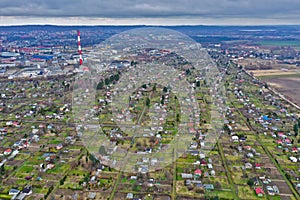 Aerial view on city allotment gardens with arbors, close to the city